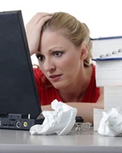 A woman looking at a laptop while stressed